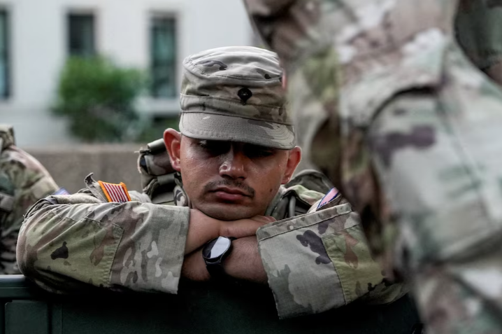 A member of the National Guard rests, after sunrise