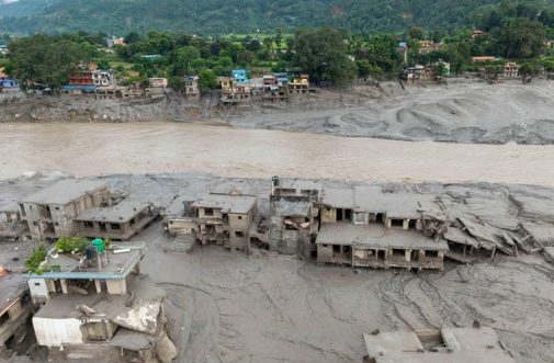 An aerial view shows houses covered in mud after flash floods