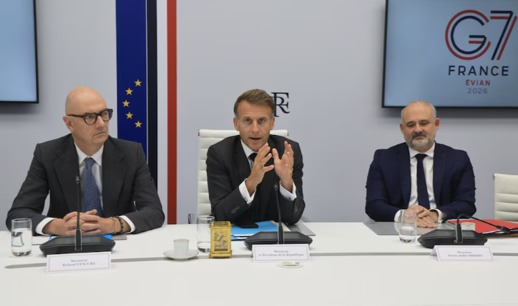 ] French President Emmanuel Macron (C) speaks next to France's Economy, Finance and Industry Minister Roland Lescure and Secretary-General